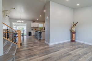 Entrance foyer with light wood-style floors and a chandelier