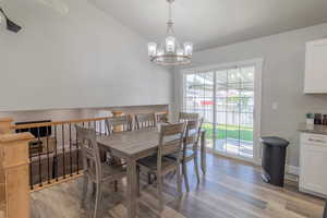 Dining space featuring lofted ceiling, light wood-type flooring, and a chandelier