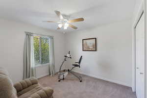 Bedroom featuring light carpet, ceiling fan, and a textured ceiling