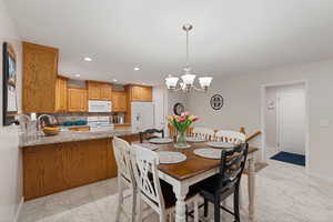 Dining area featuring a chandelier and light marble finish flooring
