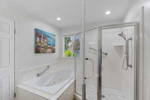 Primary bathroom featuring a stall shower, a whirlpool tub, and recessed lighting