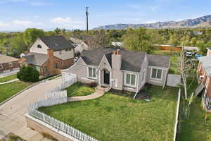 View of front of home featuring a chimney, a fenced front yard, stucco siding, and concrete driveway