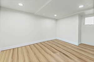 Empty room with light wood-style flooring and recessed lighting