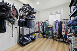Walk in closet with light wood finished floors
