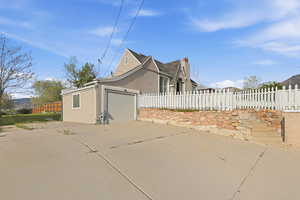 View of side of property featuring stucco siding, an attached garage, and driveway
