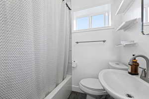 Bathroom with a sink and shower / bathtub combination with curtain