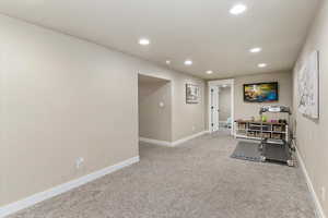 Exercise room with light colored carpet and recessed lighting