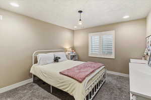 Carpeted bedroom with recessed lighting and a textured ceiling