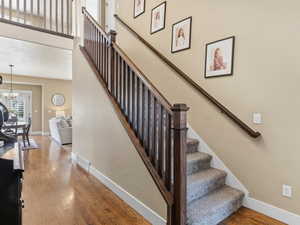 Stairway featuring wood finished floors and a high ceiling