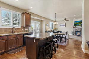 Kitchen with a center island, french doors, light stone counters, open floor plan, and backsplash