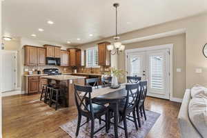 Dining space featuring french doors, light wood-style flooring, and suspended lighting