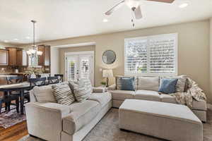 Living room with french doors, suspended lighting, and a ceiling fan