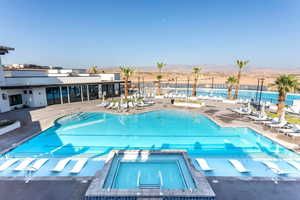 Community pool featuring a patio, a mountain view, and a hot tub