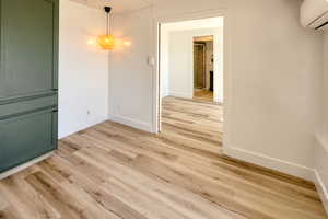 Spare room with a mini split for heating / cooling and light wood-style flooring