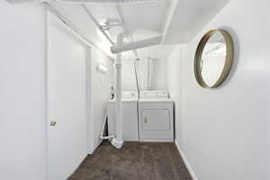 Laundry area featuring dark carpet and washer and dryer