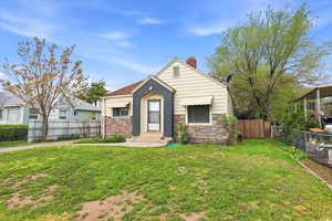 View of front of house with stone siding and a chimney