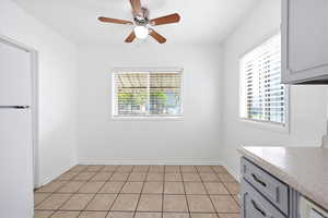 Unfurnished dining area featuring ceiling fan and light tile patterned floors