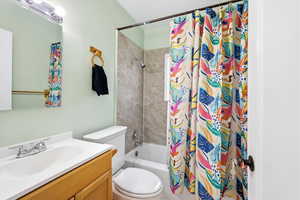 Bathroom with vanity and shower / bath combination with curtain