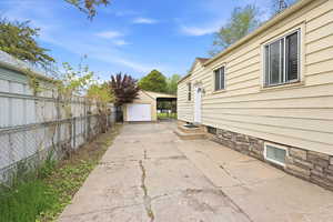 View of side of property with a garage, an outbuilding, and driveway