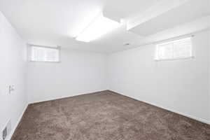 Below grade area with dark carpet and baseboards