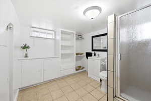 Full bathroom with vanity, a shower stall, and light tile patterned flooring