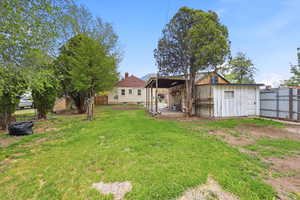 Back of house featuring a patio, a fenced backyard, and a storage shed