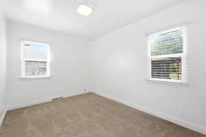 Carpeted empty room with baseboards