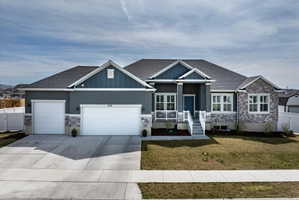 Craftsman-style home with stone siding and roof with shingles