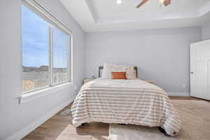 Bedroom featuring a tray ceiling, wood finished floors, ceiling fan, and recessed lighting