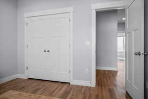 Unfurnished bedroom with dark wood finished floors and a closet