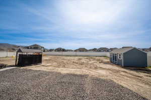 Fenced backyard featuring a residential view and an outbuilding