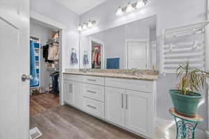 Bathroom featuring double vanity and light wood-style floors