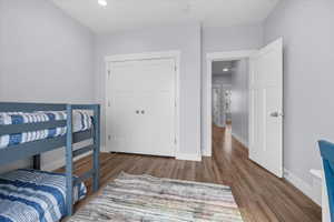 Bedroom with wood finished floors, recessed lighting, ceiling fan and a closet