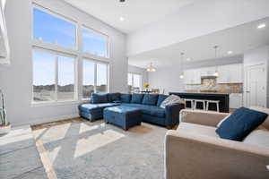 Living room featuring wood finished floors, a cathedral ceiling, fan and recessed lighting