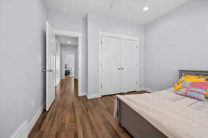 Bedroom featuring dark wood-style flooring, a closet, and recessed lighting