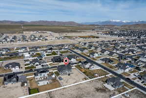 Aerial view of property and surrounding area featuring nearby suburban area and a mountainous background