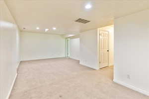 Empty room featuring light colored carpet and recessed lighting