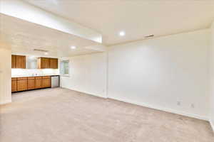 Unfurnished living room with light colored carpet, recessed lighting, and a textured ceiling