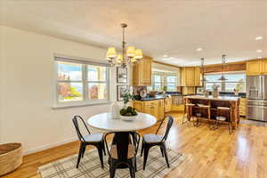 Dining space featuring a chandelier, light wood finished floors, and a textured ceiling