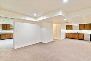 Unfurnished living room with light carpet, a textured ceiling, and recessed lighting