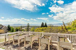 Wooden deck featuring a vegetable garden and a mountain view
