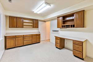 Unfurnished office with a textured ceiling and light colored carpet