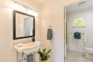 Bathroom with light floors and combined bath / shower with glass door