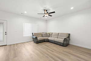 Living room with light wood-style floors, recessed lighting, and a ceiling fan