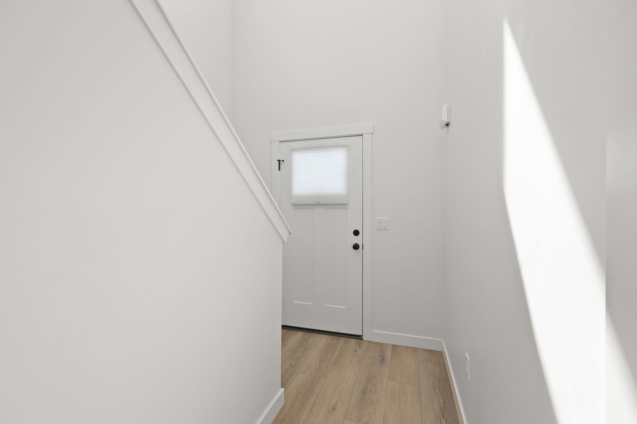 Doorway with baseboards and wood finished floors
