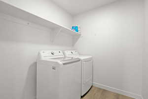 Laundry area featuring light wood-style floors and washer and dryer