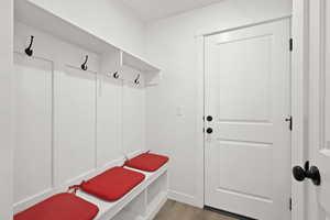 Mudroom featuring light wood-style floors and baseboards