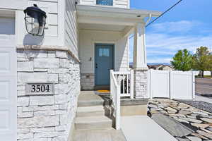 Entrance to property featuring stone siding and a porch
