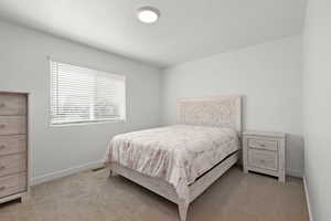 Bedroom with light colored carpet and a textured ceiling