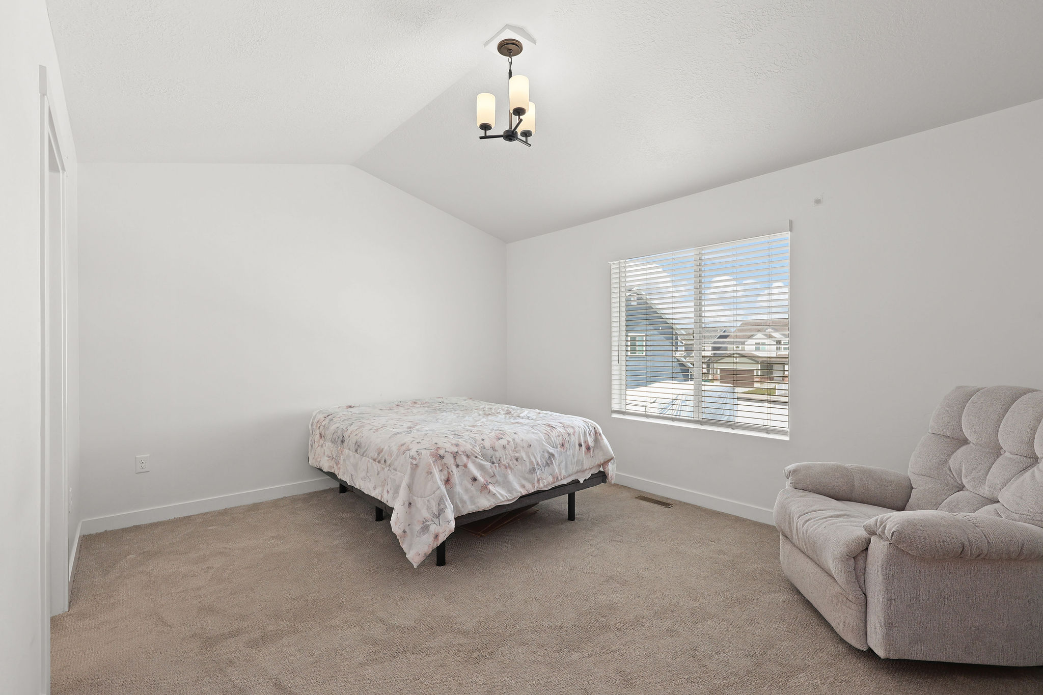 Bedroom featuring lofted ceiling and light carpet